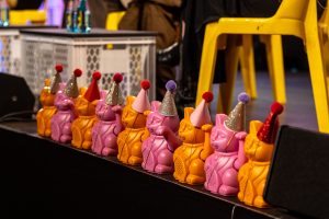 Symbolic picture: A row of lucky cats with hats on a stage.
