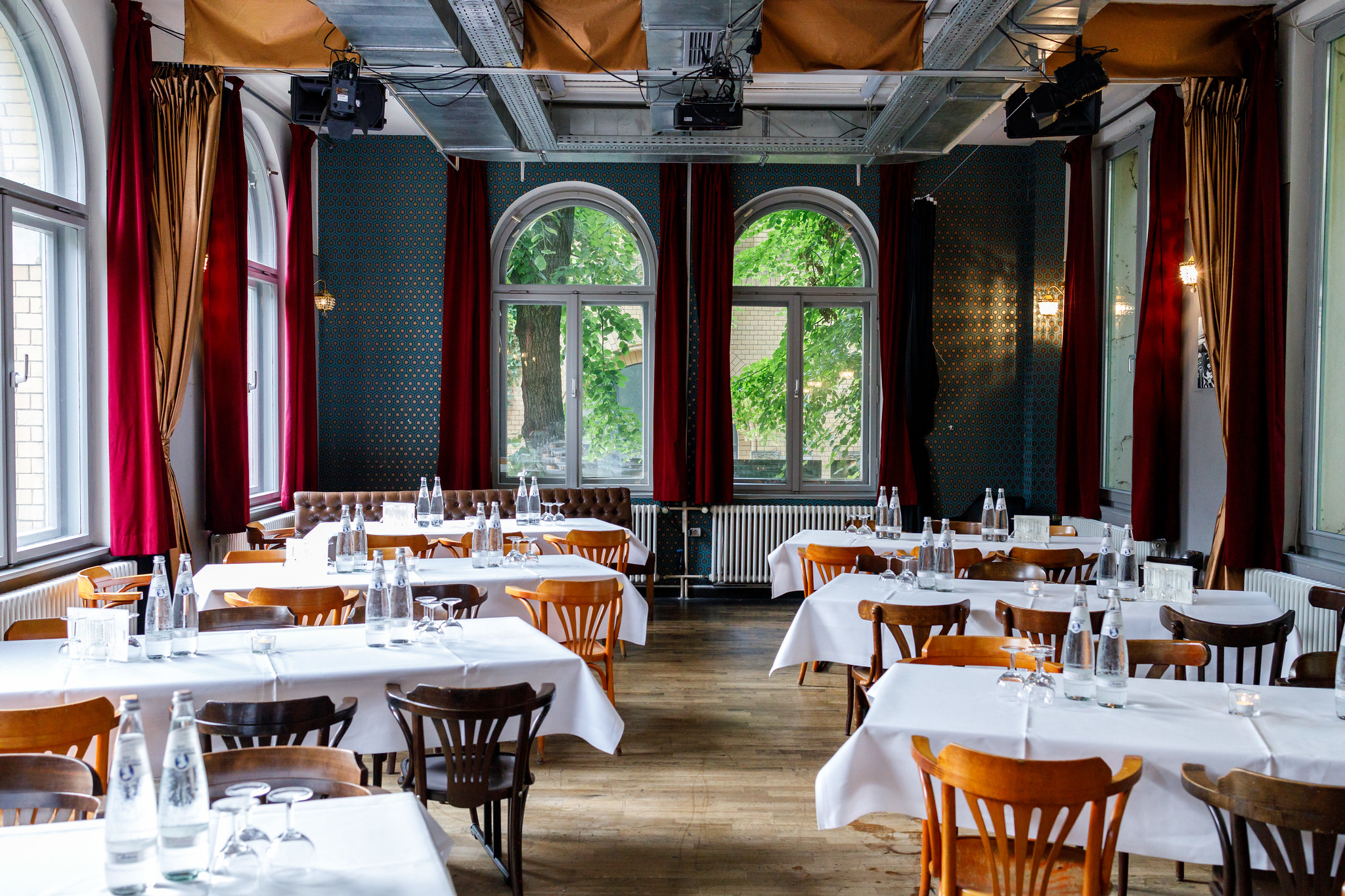 Inside of Frannz Salon: Tables with white table cloth